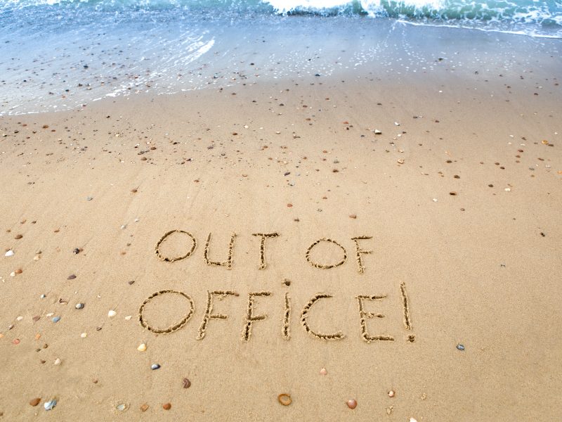 out of the office written in the sand